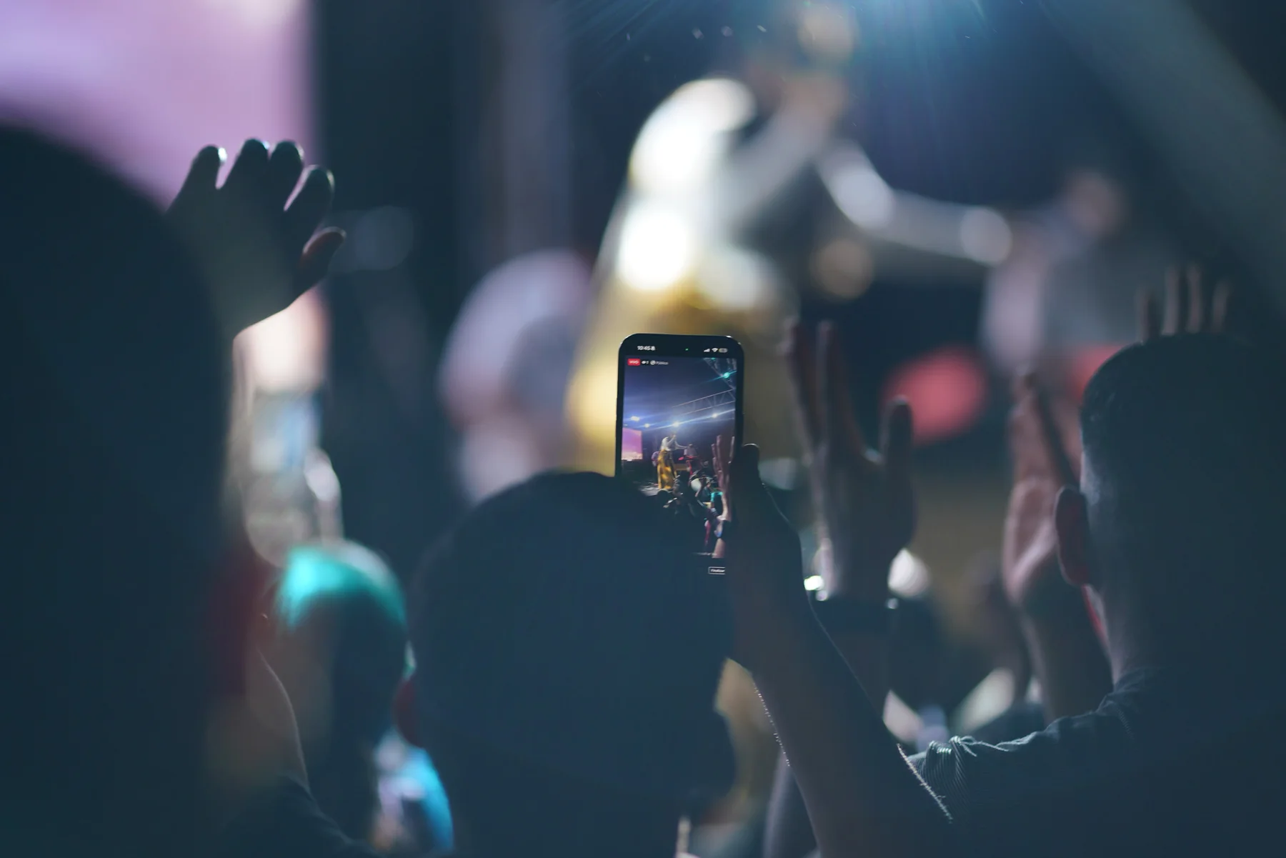 Audience member filming a live event on a phone